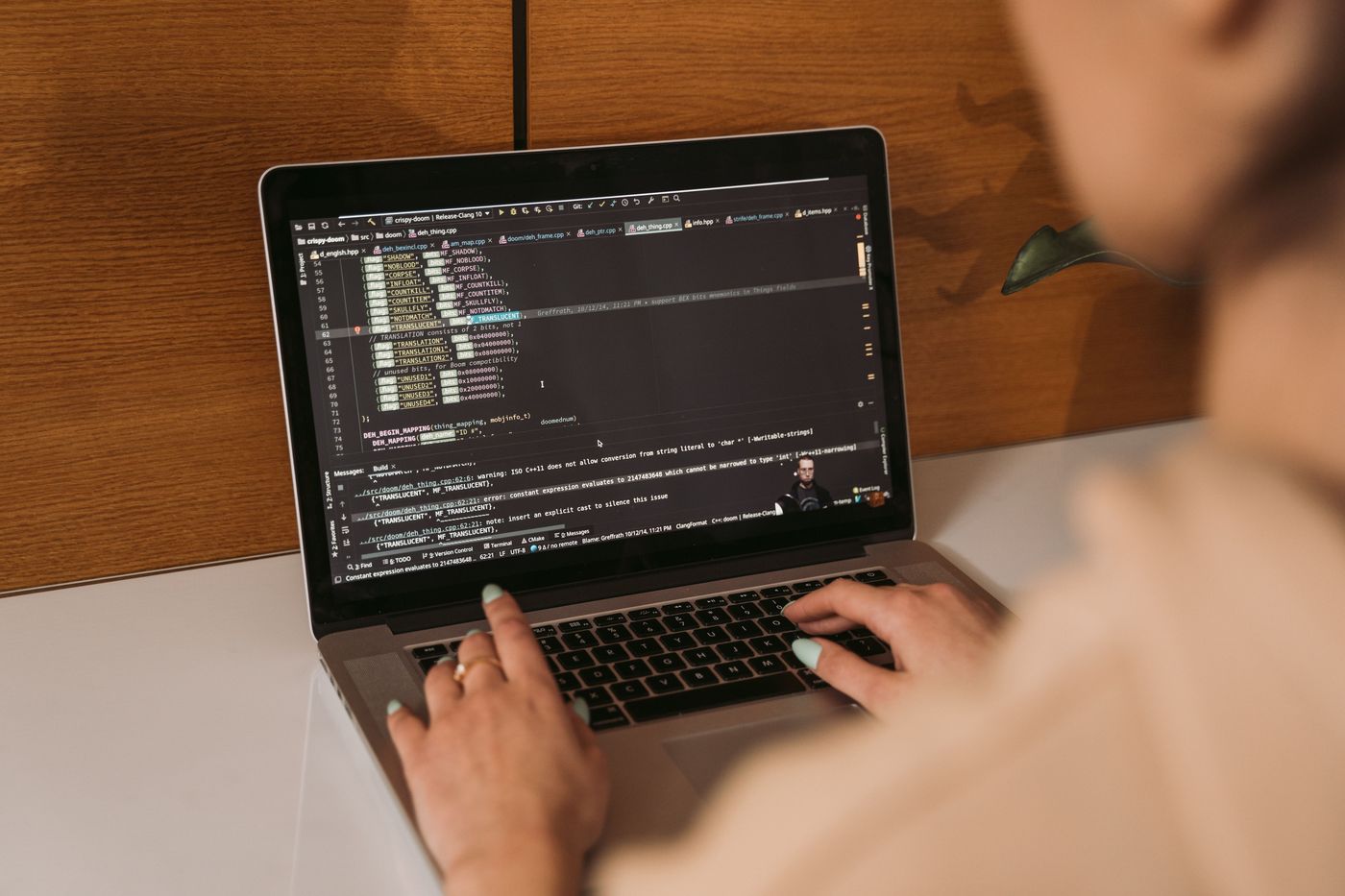 Hands typing on a laptop showing a code editor